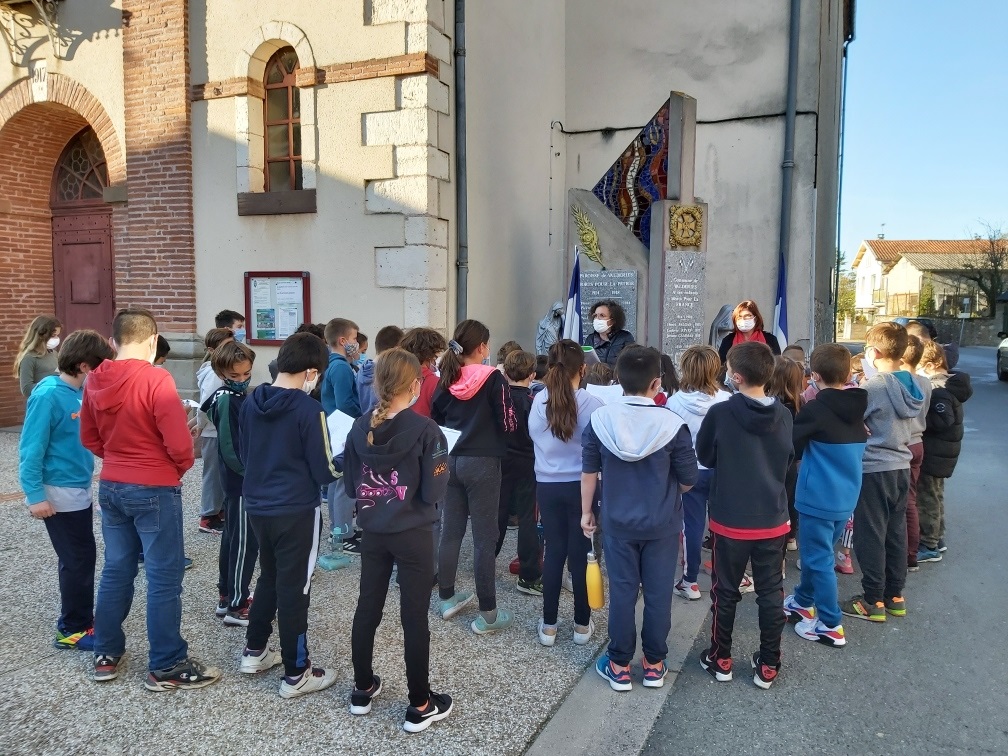 Les enseignantes et les élèves devant la monument aux Morts. Les enfants devant le monument aux Morts